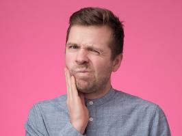 hombre con dolor de diente por caries interdental